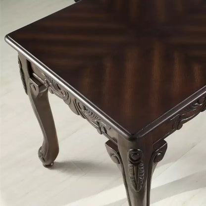 Mesa de centro de madera con detalles ornamentales tradicionales, acabado en cerezo oscuro
