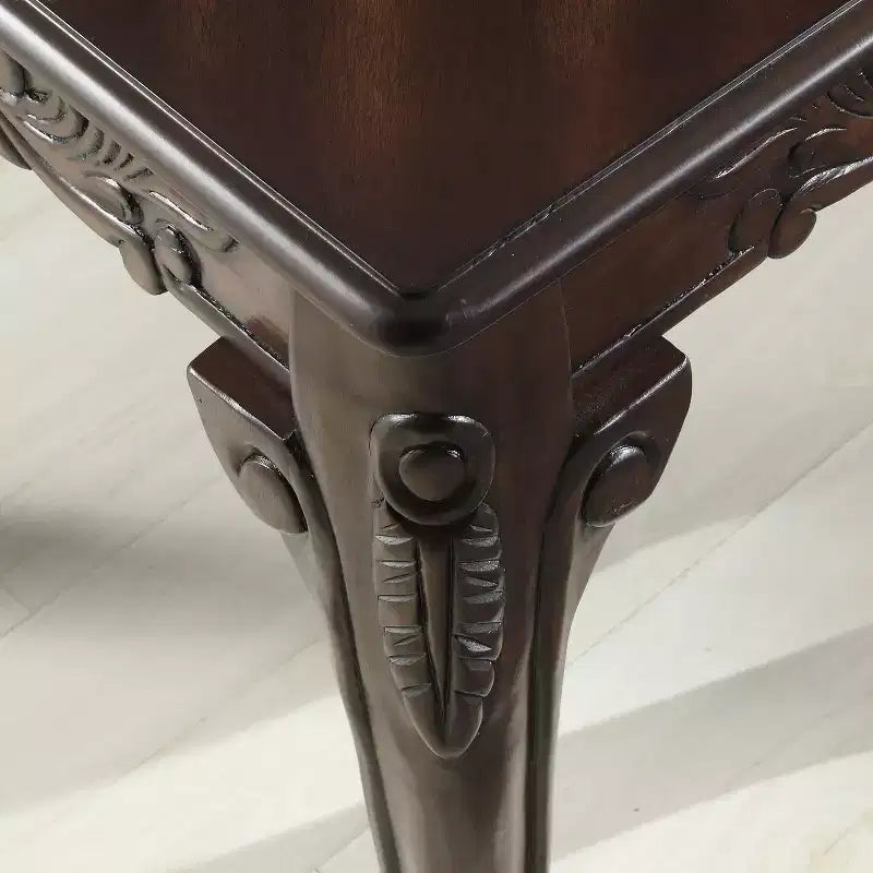 Mesa de centro de madera con detalles ornamentales tradicionales, acabado en cerezo oscuro